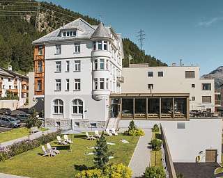 Aussenansicht des Sunstar Hotels Pontresina mit historischer Fassade, Gartenanlage und Liegestühlen
