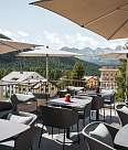Sonnenterrasse mit Sitzbereichen, Sonnenschirmen und Blick auf die Berglandschaft